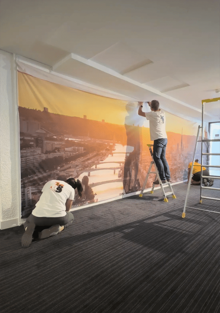 Pose d’une toile murale Le 1609 par deux poseurs